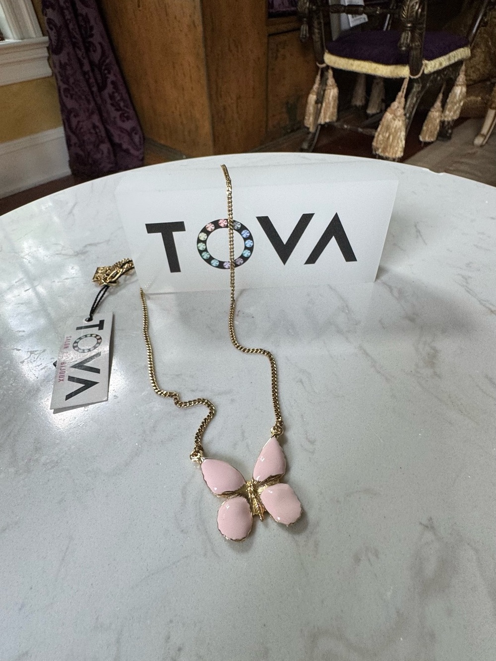 Butterfly pendant in light pink on a simple chain